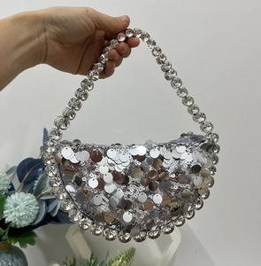 Detail of silver sequin crescent evening bag with sparkling rhinestone beaded handle