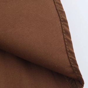 Detail shot of brown poplin fabric texture showing high-quality stitching and seam work
