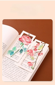 Detailed view of handmade watercolor bookmarks with floral patterns inside an open book