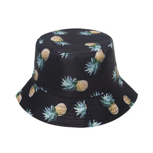 Detail view of tropical pineapple print on black cotton summer bucket hat