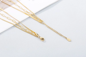Detail of layered gold necklace with stainless steel S.Steel engraved authenticity tag