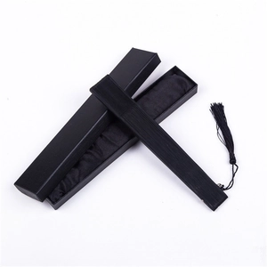Close-up of elegant black folding fan with matching tassel and premium gift packaging box
