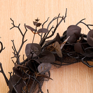 Halloween wreath with black artificial branches and mesh veil on wooden background