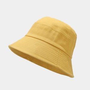 Minimalist ginger yellow cotton bucket hat with parallel stitching on plain background