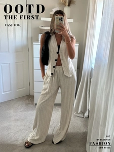 Detail of beige pinstripe vest and wide-leg trousers set with linen texture finish