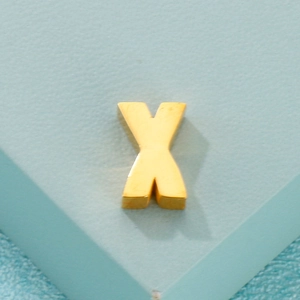 Pendentif lettre X doré minimaliste pour bijoux DIY sur fond bleu clair texturé