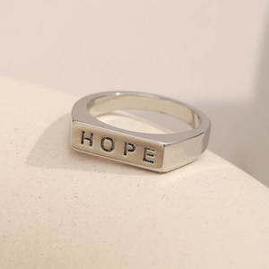 Detail-Makroaufnahme des polierten Edelstahlrings mit graviertem Hope-Schriftzug in Silber