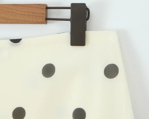 Detailed view of white polka dot chiffon skirt fabric showing texture and pattern