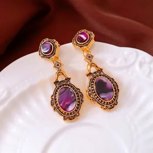 Vintage gold-plated oval earrings with purple crystals and baroque engraving details