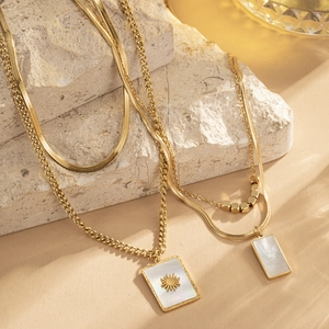 French style gold layered necklace set with rectangle shell pendant on stone background