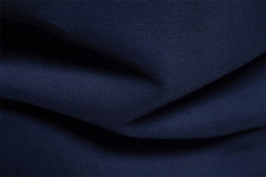 Macro shot of navy blue long sleeve sweatshirt fabric showing fine knit texture and drape