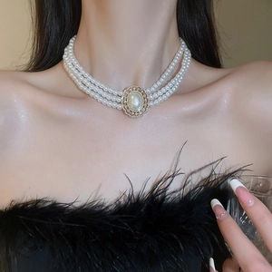 Elegant multi-layer pearl choker with crystal-encrusted pendant on a female model