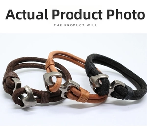 Detail view of vintage braided leather bracelets with silver metal anchor-shaped buckles
