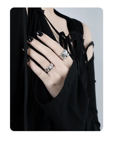 Detail of minimalist wide silver rings with liquid metal and pleated texture on finger