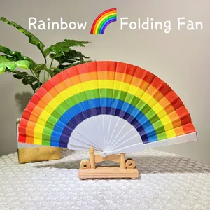Rainbow folding fan with white plastic frame and wooden display stand on a lace tablecloth