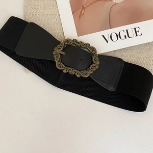 Détail de la boucle vintage en bronze sculpté sur une ceinture élastique noire chic