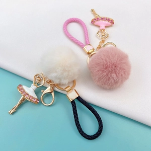 Close-up of ballet girl keychains with plush pom-poms and braided cords in pink and white