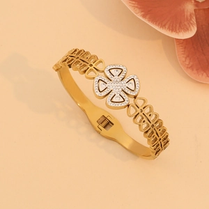 Golden tree of life bangle featuring a crystal pavé clover centerpiece with leaf accents