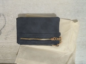 Detailed close-up of a vintage dark blue folding wallet with gold zipper on a fabric pouch