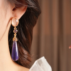Vue détaillée de boucles d'oreilles vintage en résine avec strass rose et violet