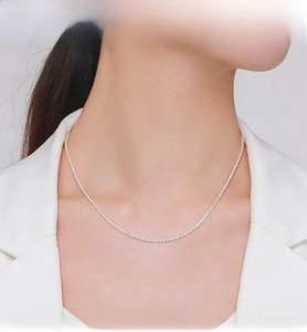 Close-up of minimalist S925 sterling silver chain necklace on female model with white suit