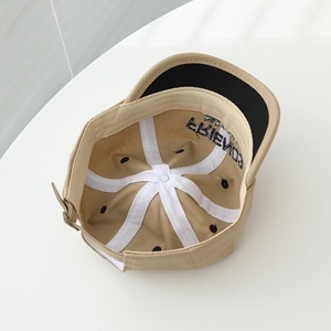 Detail of baby baseball cap interior showing white reinforcement tapes and Friends embroidery
