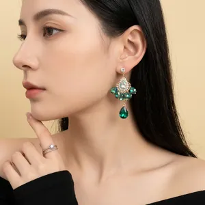 Vintage water drop earrings with emerald crystals and diamonds shown on model