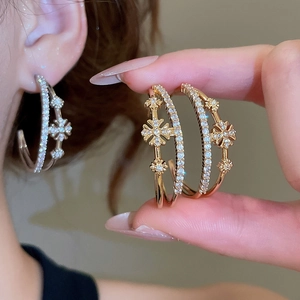 Détail des boucles d'oreilles doubles fleurs en C plaquées or 18 carats avec zircone