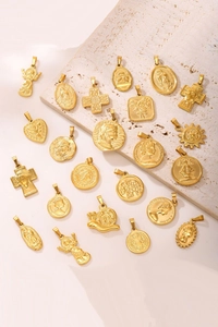 Flat lay of 18K gold-plated stainless steel pendants with religious and vintage motifs