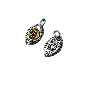 Close-up of two-tone Tibetan style metal pendants with embossed religious patterns