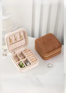 Close-up of a mini velvet jewelry box with square zipper design and organized compartments