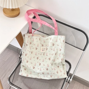 Detail of cute cartoon animal prints and brand label on a checkered canvas tote bag