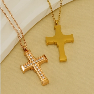 Detailed macro view of gold and rose gold stainless steel cross pendants with crystals