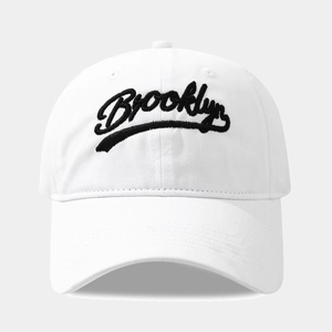 Close-up of black Brooklyn script embroidery on a white washed cotton baseball cap