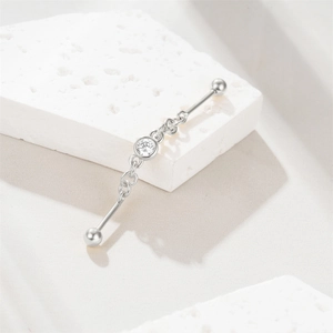Macro detail of silver S925 industrial barbell with star moon chain and zircon stone