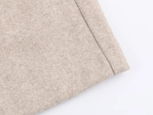 Close-up of soft oatmeal blazer fabric showing detailed wool texture and neat stitching