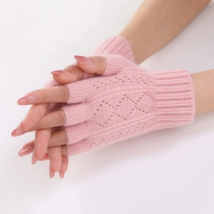 Detail of pink knitted arm warmers featuring diamond hollow patterns and fingerless design