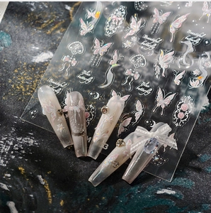 Macro shot of 3D butterfly nail stickers with iridescent aurora finish and floral patterns
