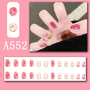 Makroansicht von rosa Ombre-Kunstnägeln mit Kirschmotiv und Glitzer-Akzenten