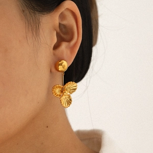 Boucles d'oreilles pendantes fleurs en acier inoxydable plaqué or 18 carats sur modèle
