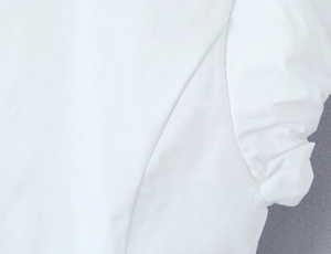 Detailed close-up of stitching and pleats on white puff sleeve vintage shirt