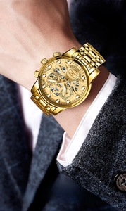Detail of luxury gold hollow mechanical watch for men on wrist with business suit