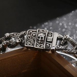 Macro shot of punk style skull head clasp and interlocking steel links on silver bracelet