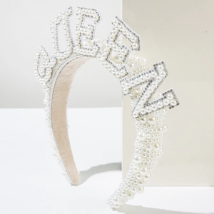 Luxury bridal headband with white pearls and rhinestones spelling QUEEN on white stand