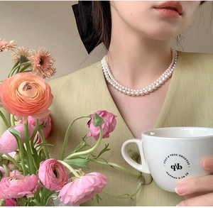 Elegant double-layer white round pearl choker necklace worn on model for a chic look