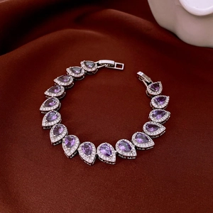 Détail d'un bracelet de luxe avec pierres violettes en goutte et pavé de zircons