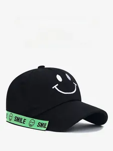 Detail of black baseball cap featuring white smile embroidery and neon green SMILE ribbon