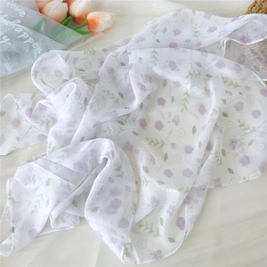 Detail of white square scarf with purple floral print in a soft, breathable fabric