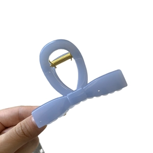 Light blue butterfly hair claw clip with glossy finish and gold metal spring closure