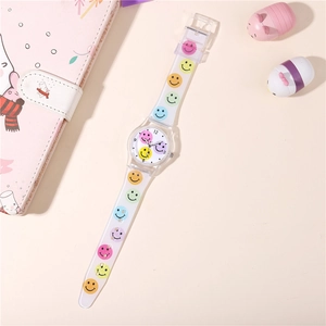 Detail of a kids quartz watch with colorful smiley face prints on a clear resin strap